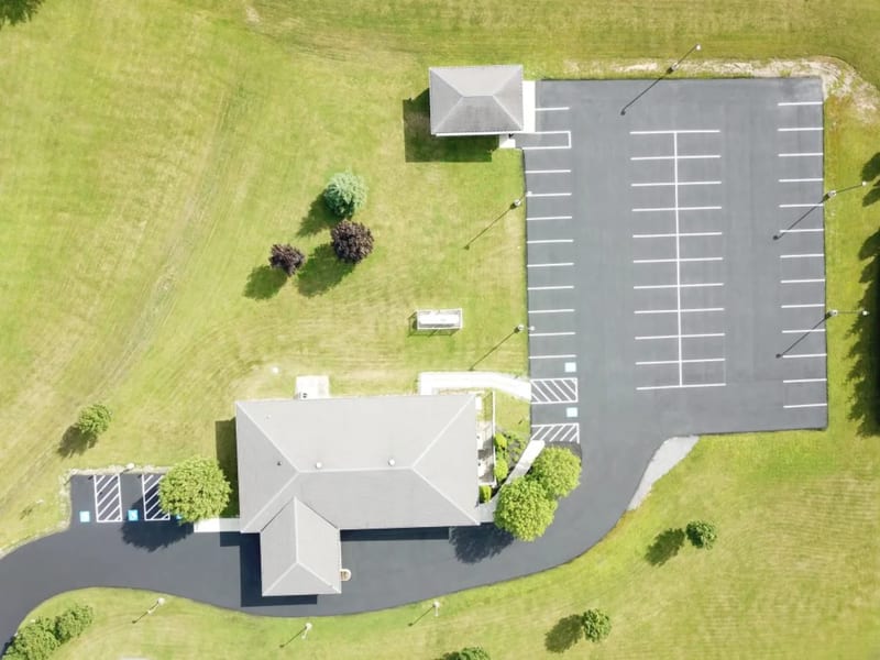 Aerial view of a sealcoated commercial parking lot with fresh line striping